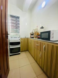 a kitchen with a stove and a microwave at Luxury and premium one bed in Ikeja