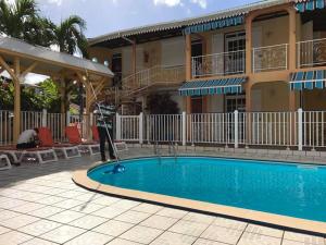 a man standing next to a swimming pool at La Pointe d'Argent in Pointe-Noire +8 photos
