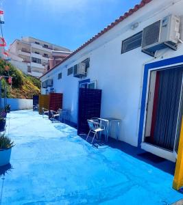 a patio with chairs and a white building at vila gira odeceixe in Odeceixe