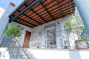 a house with a balcony with a wooden roof at Rosa di Ischia - Holiday in Ischia Town