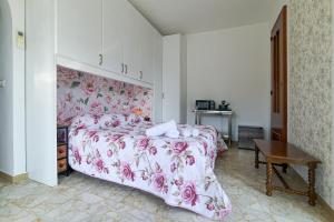 a bedroom with a bed with a pink floral bedspread at Rosa di Ischia - Holiday in Ischia Town +7 photos