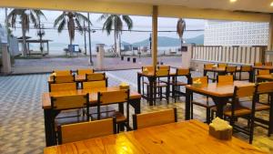 a restaurant with tables and chairs and a view of the beach at Panwa Beach Side Beachfront in Panwa Beach