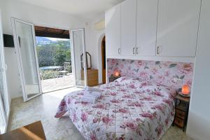 a bedroom with a bed with a pink floral bedspread at Rosa di Ischia - Holiday in Ischia Town
