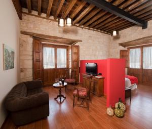 a living room with a couch and a tv at Concejo Hospederia in Valoria la Buena