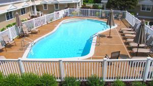 a large swimming pool with chairs and umbrellas at 215 Heritage Lane in Cape May