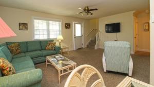 a living room with a green couch and chairs at 215 Heritage Lane in Cape May