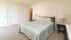 a bedroom with a bed and two tables and a lamp at 215 Heritage Lane in Cape May +15 photos