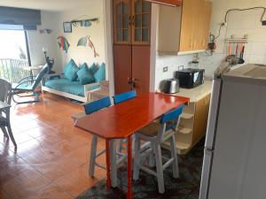 a kitchen and living room with a wooden table and chairs at Apartamento Playa Mar Azul in El Quisco