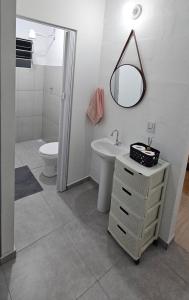 a bathroom with a toilet and a sink and a mirror at Casa Completa e Confortável em Cotia in Cotia