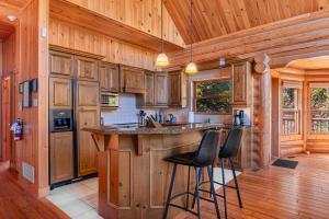 a kitchen with wooden cabinets and a bar with stools at Fiddler Lake Resort - Rabbit 66 in Mille-Isles