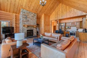 a living room with couches and a stone fireplace at Fiddler Lake Resort - Rabbit 66 in Mille-Isles