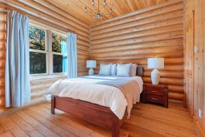 a bedroom with a bed in a log cabin at Fiddler Lake Resort - Rabbit 66 in Mille-Isles +15 photos