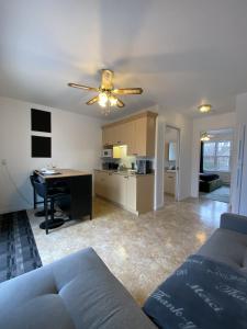 a living room with a couch and a ceiling fan at LE 710 Maison d'invitée in Saint-Georges