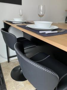 a table with a black chair in front of a table at LE 710 Maison d'invitée in Saint-Georges