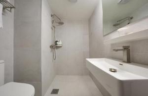 a white bathroom with a sink and a toilet at Pampas Hotel Jeju in Jeju +53 photos