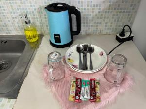a counter top with a coffee maker and a plate and glasses at Ally home 0624 in Thung Si Kan