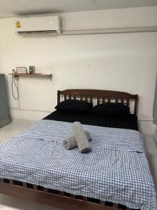 a bed with a pair of slippers on it at Ally home 0624 in Thung Si Kan