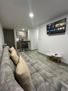 a living room with a couch and a flat screen tv at Apartamento para 6, Aeropuerto, Cerca Parque del Café, Horeb Confort in La Tebaida
