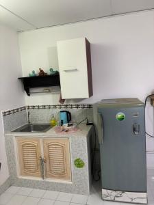 a small kitchen with a sink and a refrigerator at Ally home 0624 in Thung Si Kan