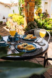 a table with plates of food and two glasses of orange juice at Casa Raisol Barichara in Barichara
