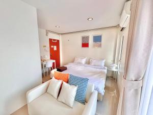 a small bedroom with a bed and a couch at Boon Poshtel Hatyai in Sathani Hat Yai
