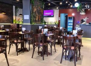 a dining room with wooden tables and chairs at Executive Flat in Apart Hotel in Campinas