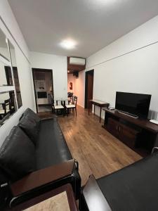 a living room with a couch and a piano at Executive Flat in Apart Hotel in Campinas