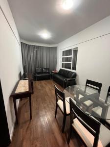 a living room with a glass table and a couch at Executive Flat in Apart Hotel in Campinas +8 photos