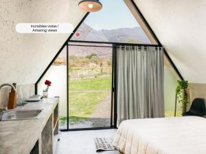 a room with a bed and a sink and a large window at Portal M Chalets in Chalma +6 photos