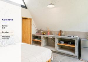 a room with a bed and a kitchen with a counter at Portal M Chalets in Chalma
