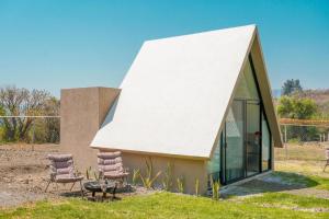 a house with a white roof and two chairs at Portal M Chalets in Chalma