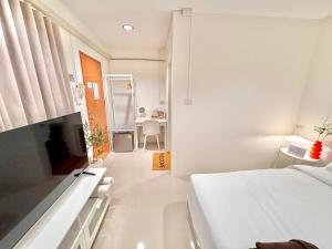 a white bedroom with a bed and a bathroom at Boon Poshtel Hatyai in Sathani Hat Yai +13 photos