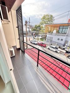 a balcony with a view of a street with cars at Boon Poshtel Hatyai in Sathani Hat Yai