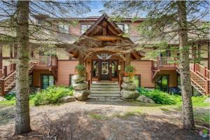 a home with a wooden house with a porch at Superb ski inout - Ask about summer pool access! in Mont-Tremblant