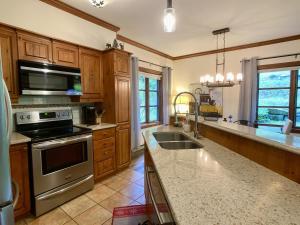a kitchen with stainless steel appliances and wooden cabinets at TRUE ski inout - large heated pool in summer! in Mont-Tremblant