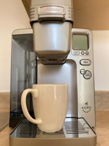 a coffee maker with a coffee cup on a counter at LE 710 Maison d'invitée in Saint-Georges