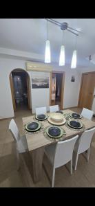 a dining room table with white chairs and blue plates on it at Mediterraneo in Peniscola