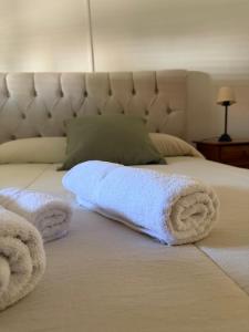 a pile of towels on a bed at Casa Arenales in Chascomús