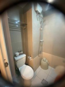 a small bathroom with a toilet and a shower at Isaiah CityScape in Manila +11 photos