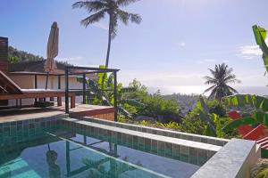 a resort pool with a view of the ocean at Secret Garden Eco Pool Villas in Ko Tao