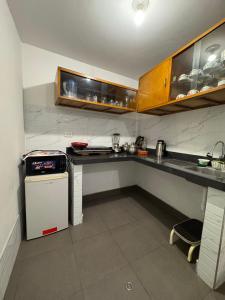 a kitchen with a counter and a small refrigerator at Antuquita's House in Cusco