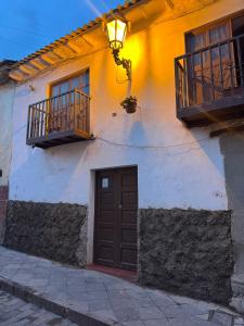 a white building with a door and a balcony at Antuquita's House in Cusco