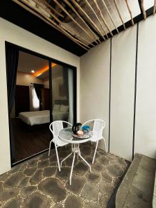 a table and chairs on a balcony with a bedroom at The Olla Villa in Yogyakarta
