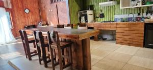 a kitchen with a wooden table and some chairs at casa caburgua en cerro in Caburgua +5 photos