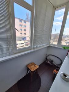 a room with three windows and a wooden stool at затишна квартирка in Kremenchuk +3 photos