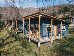 a blue house in the middle of a field at Wincarayen Lodge & Cabañas in Panguipulli