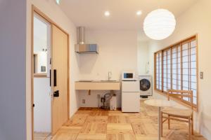 a kitchen and dining room with a table in a room at まちやど半歩 in Shimo-suwa