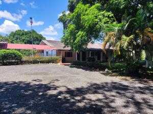 a house with a palm tree in front of a driveway at Hotel Campo Verde in Villagarzón