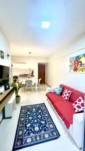 a living room with a red couch and a kitchen at Apt 3 quartos com área de lazer in Belém