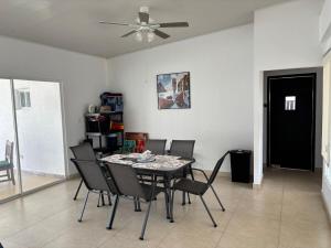 a dining room with a table and chairs and a ceiling fan at Beach House in Coronado in Nueva Gorgona
